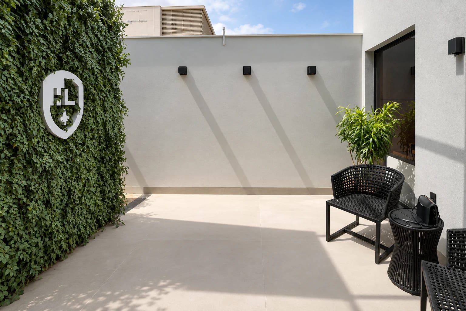 Pátio interno da unidade de Irecê, com o brasão do escritório sobre um jardim vertical.
